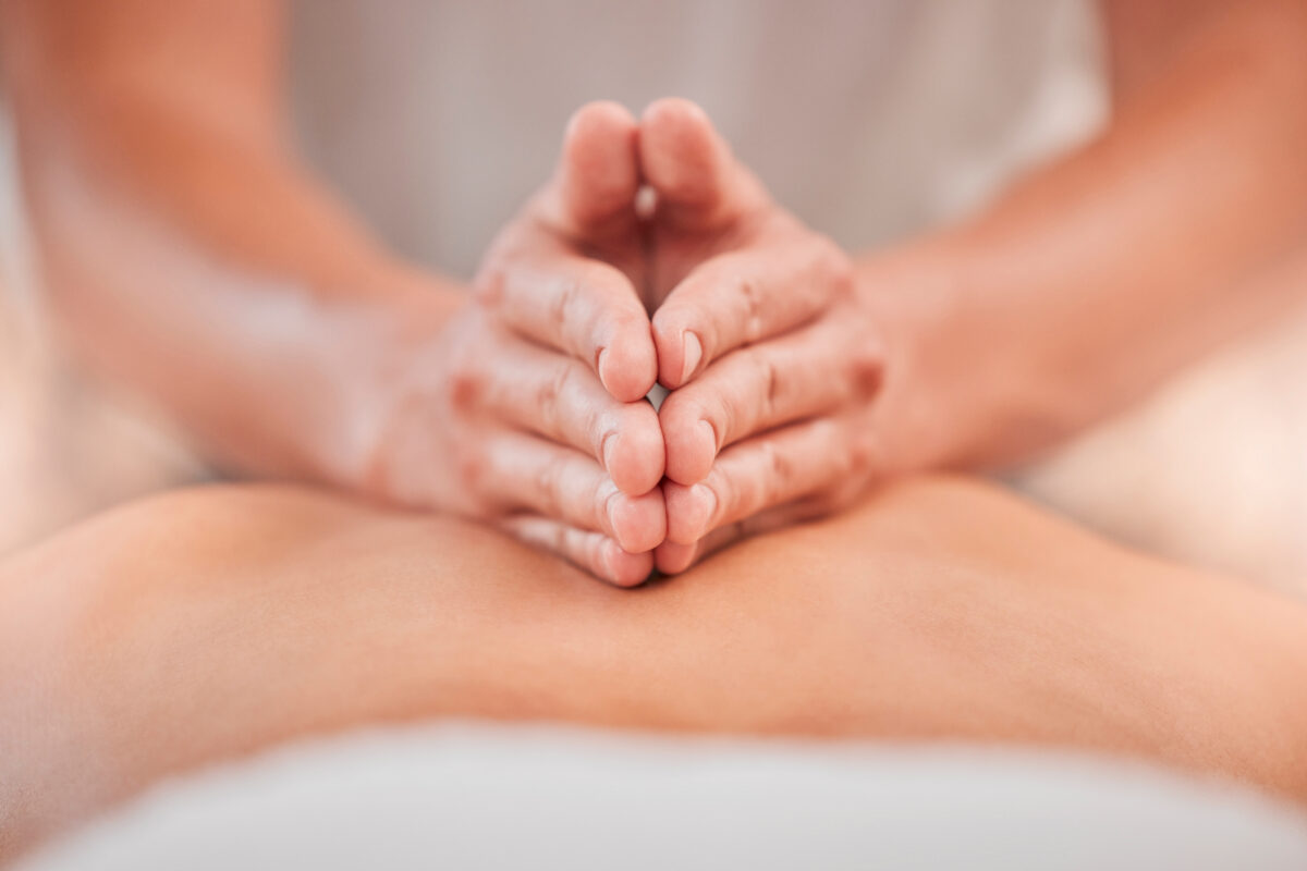 Massage therapist applying deep, focused pressure with hands during a deep tissue massage session.