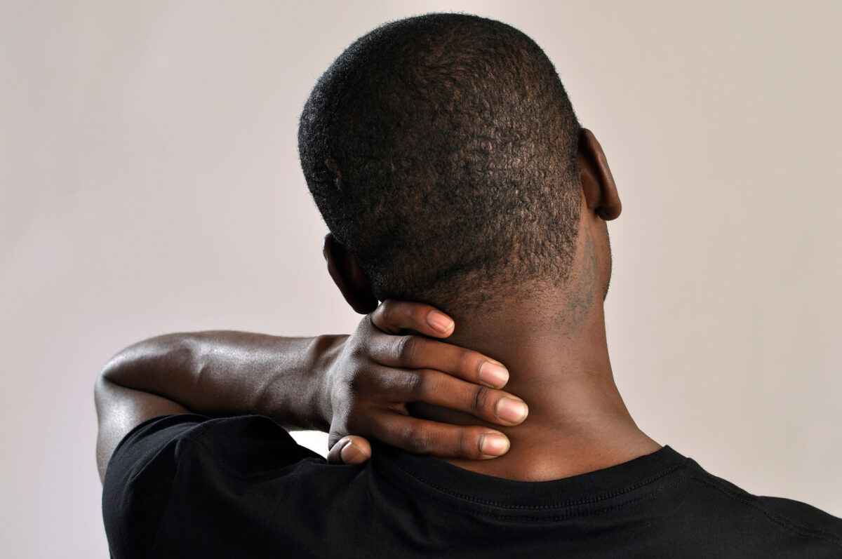Back view of a man holding his neck due to discomfort or stiffness