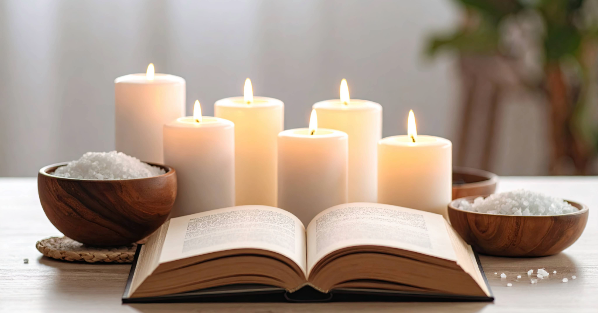 A serene spa setting with an open book placed on a wooden surface, surrounded by glowing white candles and small wooden bowls filled with bath salts, creating a calm and relaxing atmosphere.
