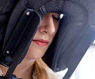 Close-up of a female office worker resting her face in a chair massage cushion with eyes closed