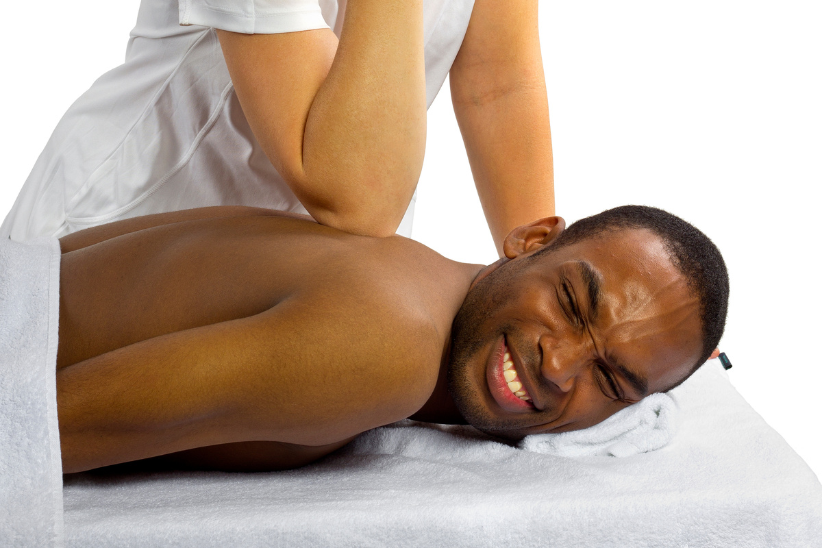 Male client receiving firm elbow pressure on the back during a deep tissue massage.